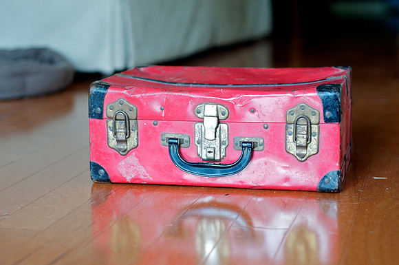 red vintage suitcase.  cute with white blanket and baby on top